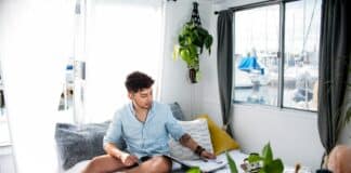 man sitting on bed near window