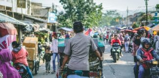 selective photography of man pedaling wagon
