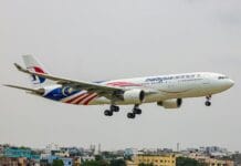 A large jetliner flying through a cloudy sky
