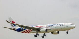 A large jetliner flying through a cloudy sky