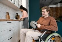 A man in a wheel chair in a kitchen