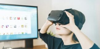 woman using black VR headset beside computer
