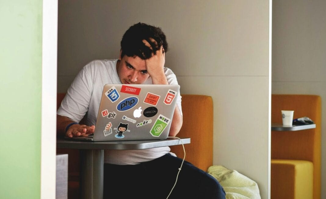 man wearing white top using MacBook