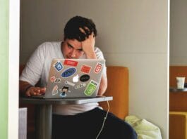 man wearing white top using MacBook