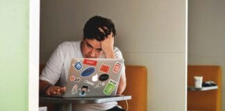 man wearing white top using MacBook