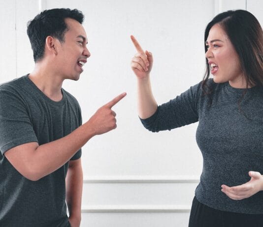 man in gray crew neck long sleeve shirt standing beside woman in black crew neck shirt